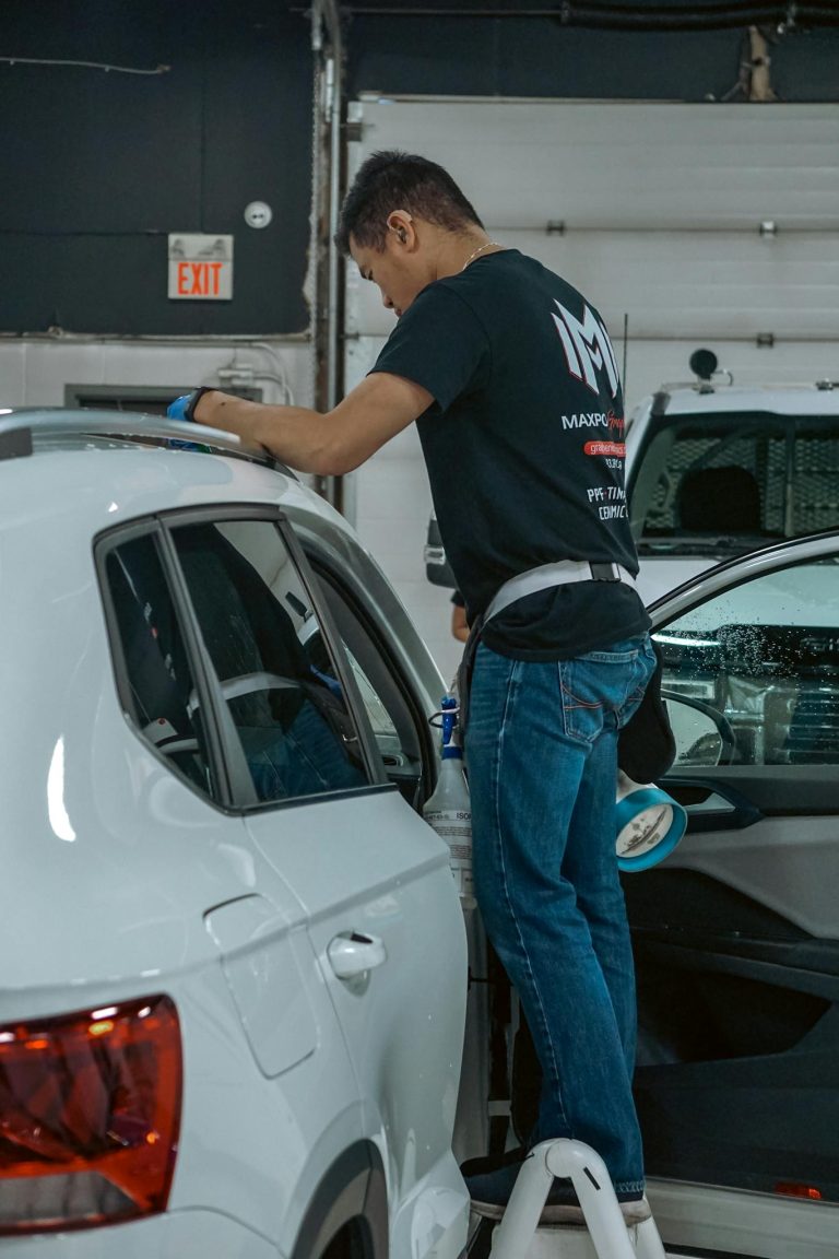 Mechanic in garage servicing a vehicle in Calgary, Alberta, Canada.